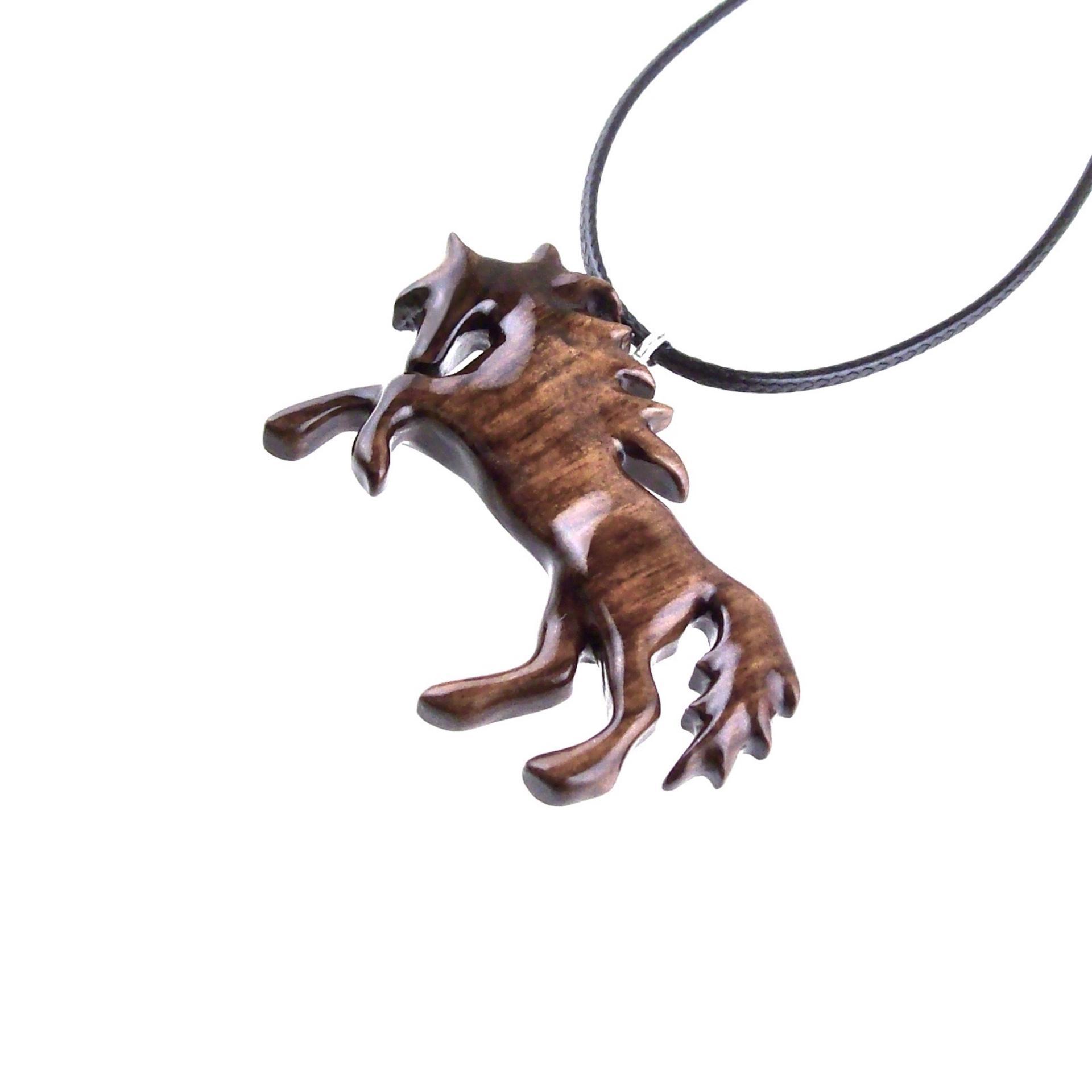 A wooden horse pendant necklace with a black cord. The horse is brown and has a detailed mane and tail.