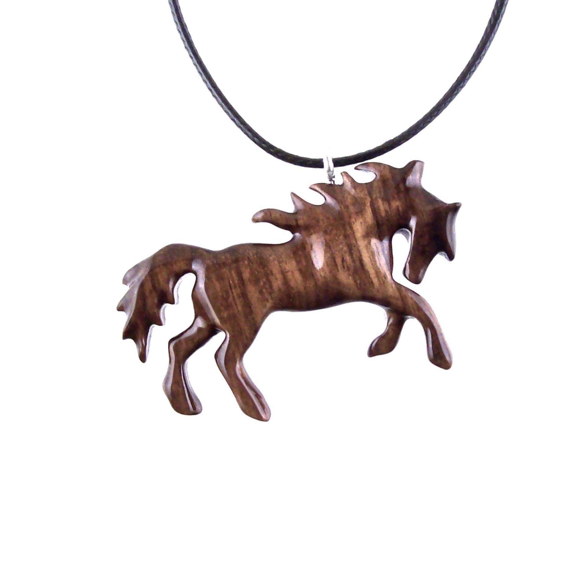 A wooden horse pendant necklace with a black cord. The horse is brown and has a detailed mane and tail.