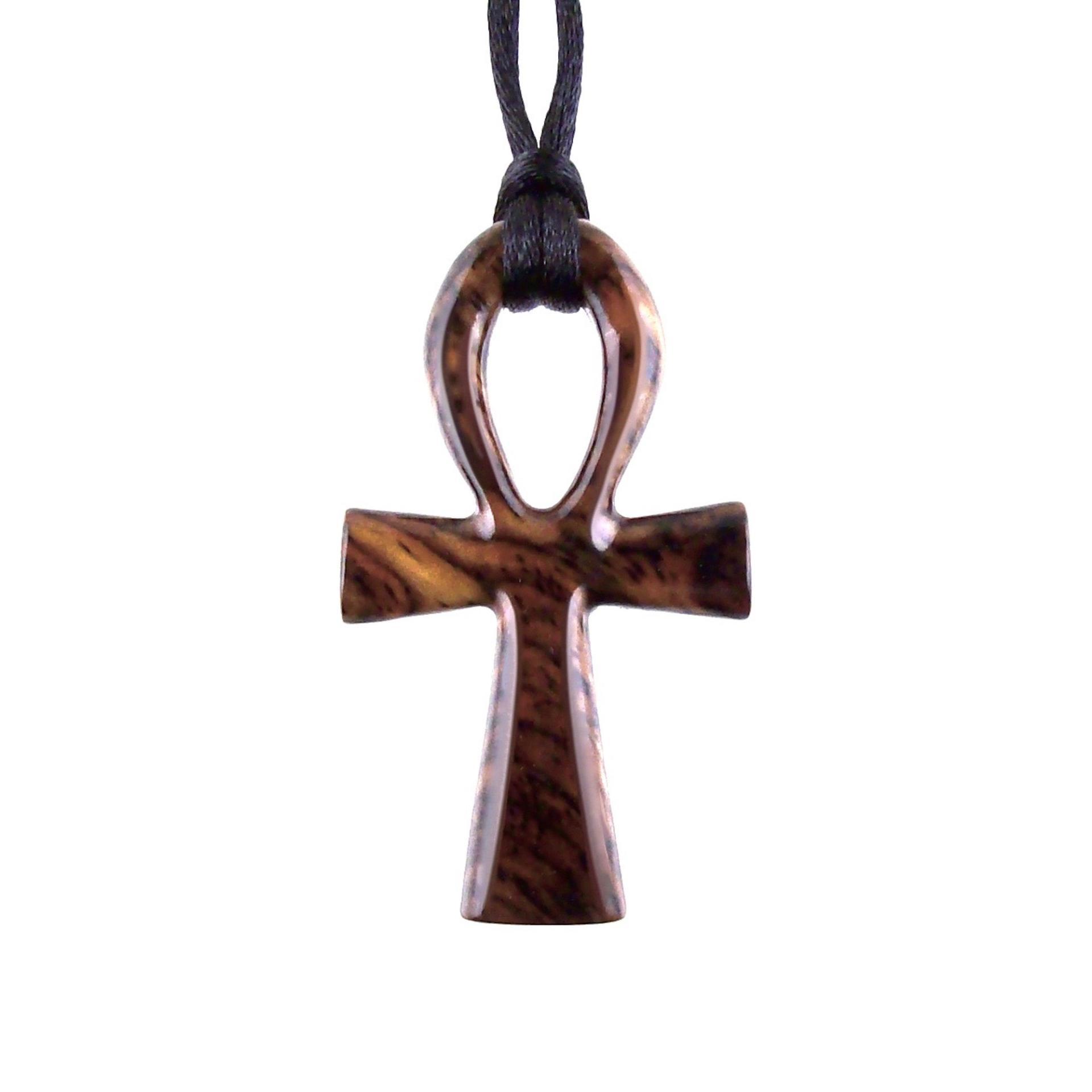 A wooden ankh pendant necklace with a black satin cord. The ankh is reddish-brown with a wood grain pattern.