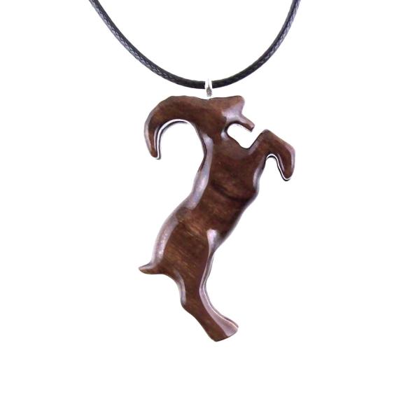 A wooden pendant shaped like a goat standing on its hind legs. The pendant is brown and has a natural wood grain pattern. The pendant is hanging from a black cord.